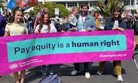 Banner in protest march on pay equity reading 'Pay equity is a human right'